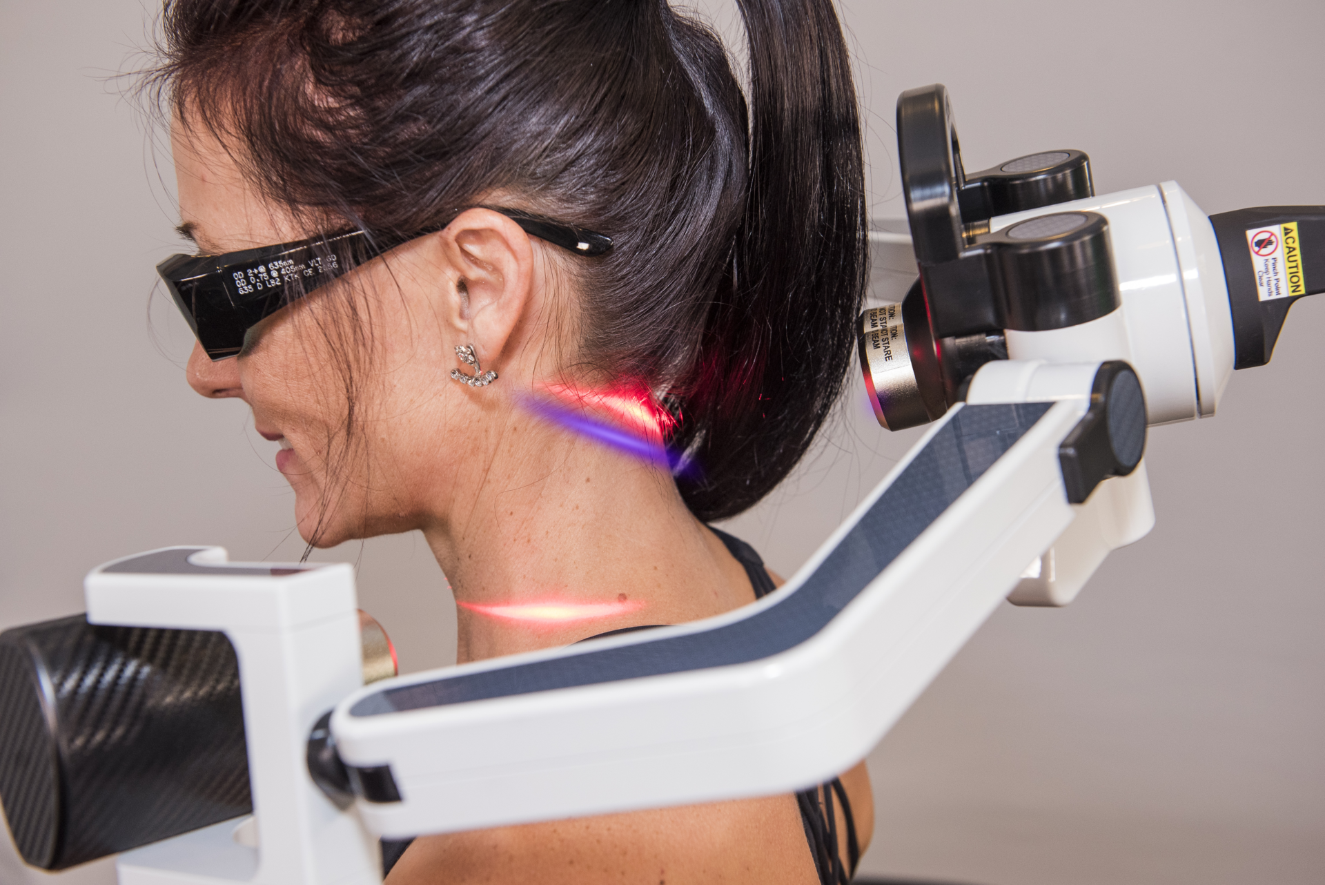 FX 405 cold laser being used on the back of a woman's neck