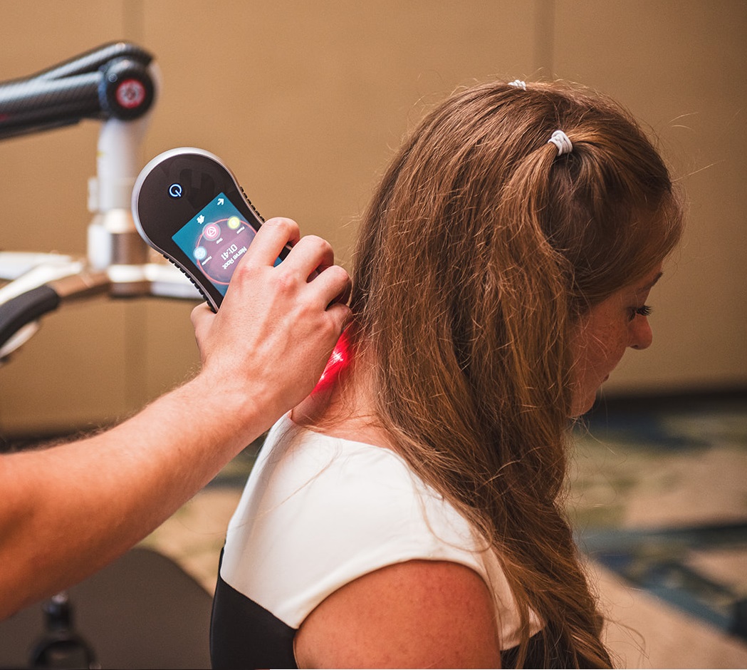 XLR8 handheld laser being used to treat woman's neck pain