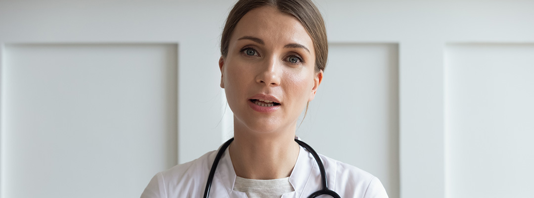 Headshot portrait woman doctor talking about fat metabolism, young female wearing white uniform with stethoscope speaking