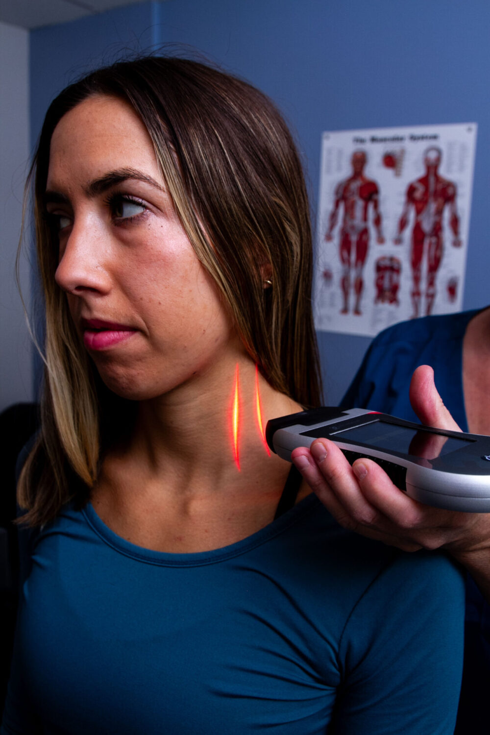 An XLR8 laser applied to a patient’s neck in a chiropractic office