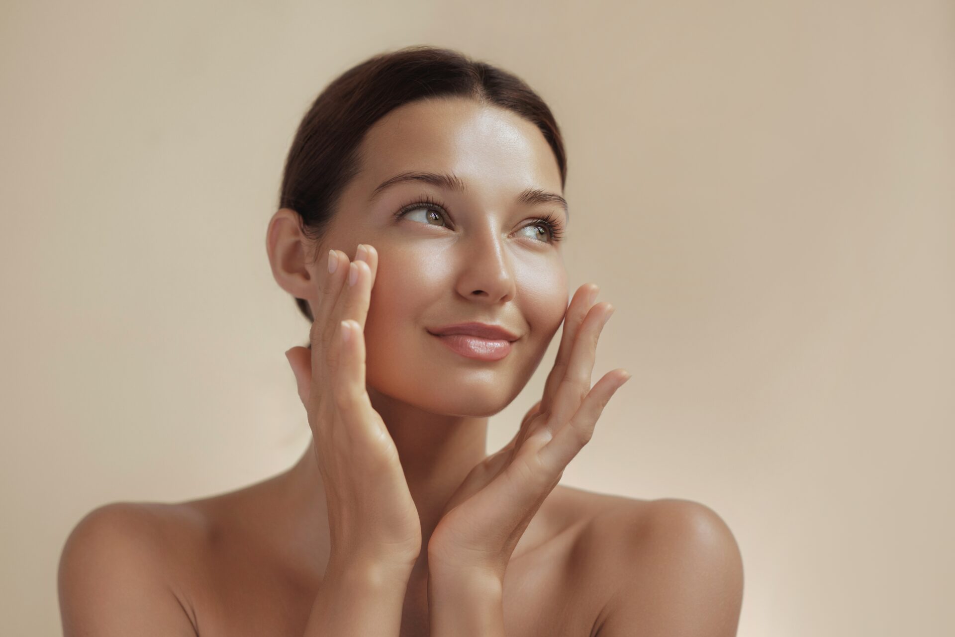 Woman with smooth, rejuvenated skin touching her face, representing the anti-aging benefits of low-level laser therapy for skin rejuvenation