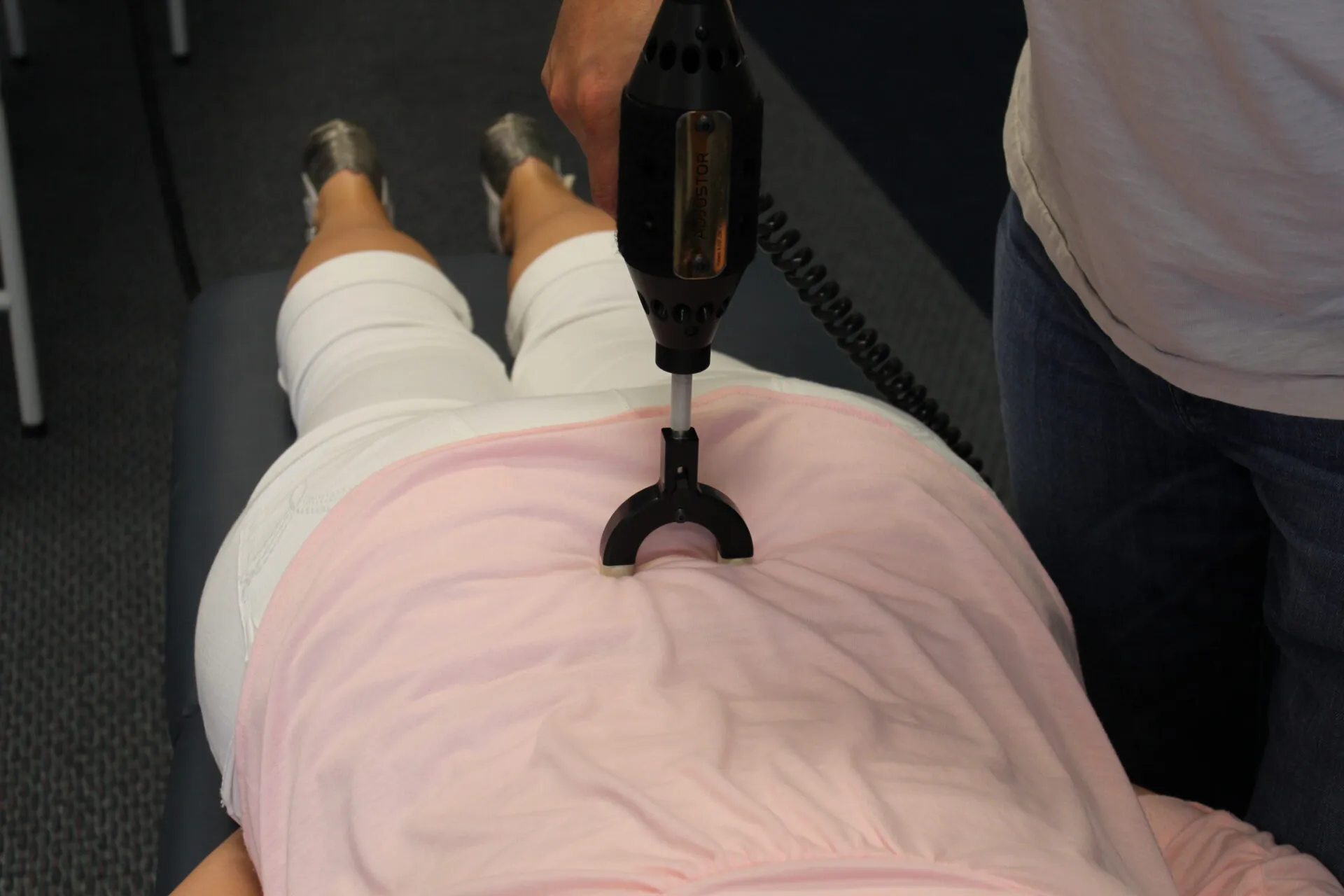 The Erchonia Adjustor in use on a patient’s lumbar spine