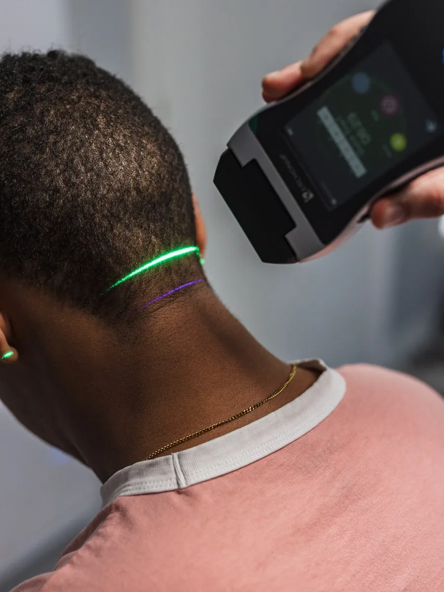 A handheld laser applied to a patient’s neck in a clinic