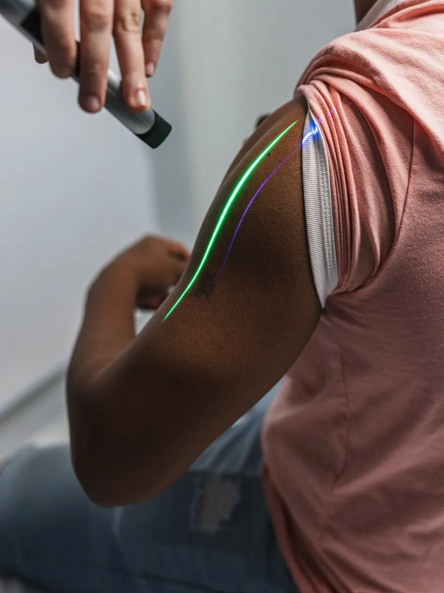 A handheld laser applied to a patient’s upper arm