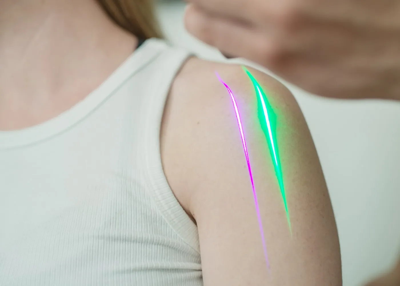 A handheld Erchonia laser line on a patient’s shoulder in a treatment room