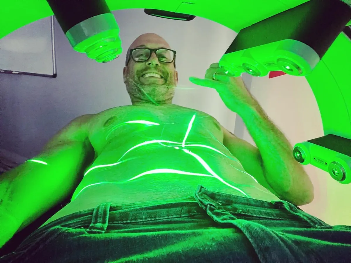 A patient smiling beneath the Emerald laser
